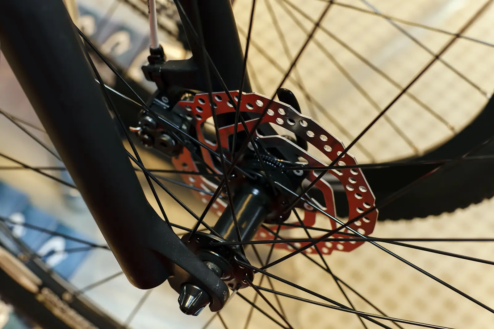 Front disc brake caliper mounted on a mountain bike fork leg with the rotor passing through it